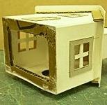 This sub-base made of corrugated cardboard provides a little more strength to the house and gives a better surface for gluing to the base.  Click for bigger photo.
