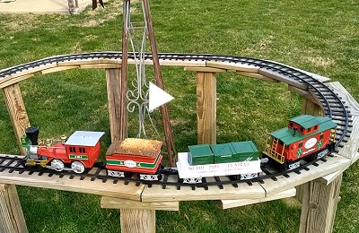 The Lionel Ready-to-Play Holiday Central train running on an elevated roadbed outdoors.  Click to see the video.