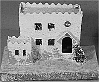 Except for the pointed porch roof, this house could have been built in Bethlehem; most putz house collections had at least one flat-roofed house that looks like it was made to go with the Nativity. Click for a slightly larger photo.